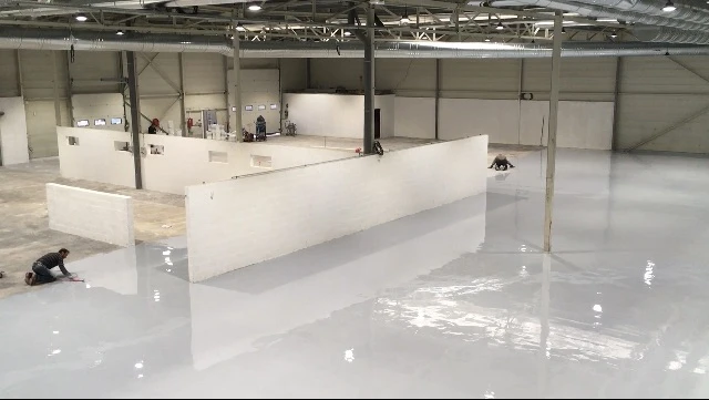 Application professionnelle de résine pour sol dans un bâtiment industriel – Pose de résine haute performance pour une surface résistante et esthétique.